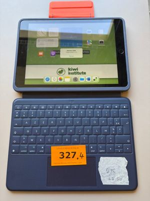 a tablet computer sitting on top of a table with a keyboard
