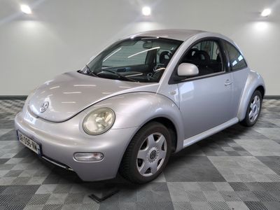une photo d'une Coccinelle Volkswagen argentée garée dans un garage