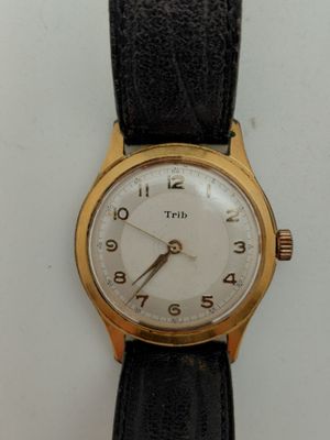 une montre-bracelet en or avec un cadran blanc et un bracelet en cuir noir