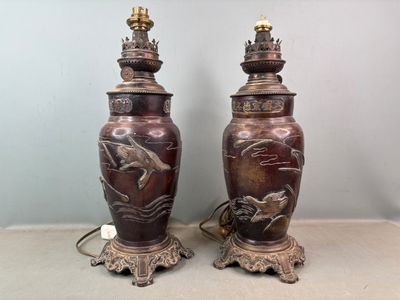 une paire de grands vases en bronze ornés de chevaux, posés sur une table