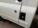 a white van that has a door open on the side of the road