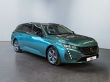 the green car is parked in a large room with a white wall