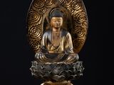 une statue représentant un Bouddha assis sur une fleur de lotus