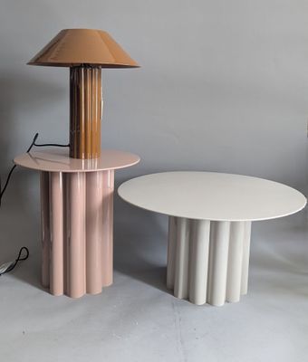 a table with a lamp on top of it next to a table with a lamp on top of it