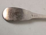 a silver spoon with writing on it sitting on a table