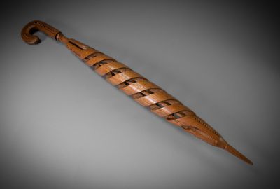 an image of a wooden umbrella that is on a gray surface