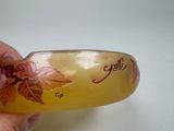 a hand holding a yellow bracelet with a flower design on it