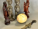 three figurines and a knife on a table