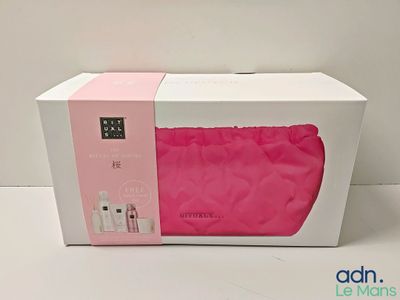 an open box with a pink bag inside of it on a white surface