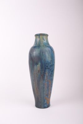 un vase bleu posé sur une surface blanche