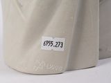 a white vase with a label on it sitting on a table