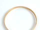 a gold bracelet and a gold ring on a white surface