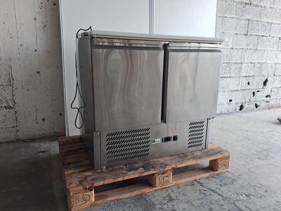 un réfrigérateur posé sur une palette dans un entrepôt