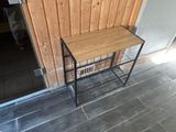 a small table with a wooden top on a tiled floor