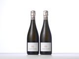 two bottles of wine sitting next to each other on a table