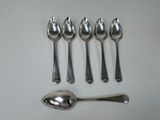 five spoons and a spoon on a white table