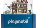 une vitrine Playmobil contenant une maison de poupées