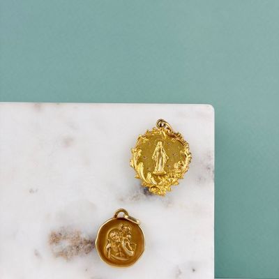 deux médailles d'or posées sur une dalle de marbre blanc