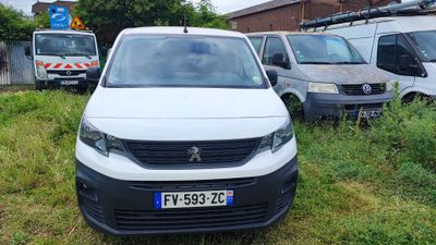 une camionnette blanche garée dans l'herbe