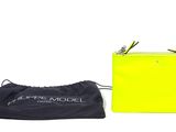 a yellow purse sitting next to a black bag on top of a white surface