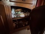 un placard dans la cuisine sur lequel sont posés de la vaisselle et des tasses