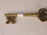 a close up of a golden key on a white surface