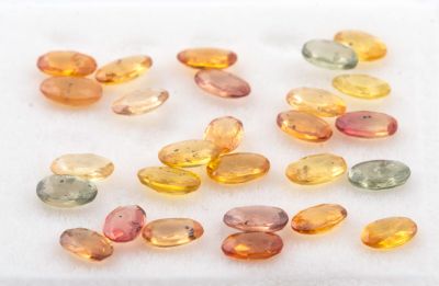 un assortiment de pierres précieuses de différentes couleurs posées sur une surface blanche