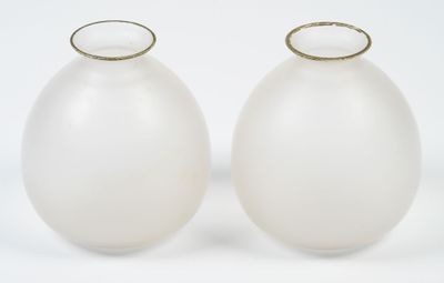 two white vases sitting next to each other on a white surface