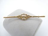 a close up of a gold hair pin with pearls on it