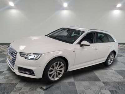 Une Audi blanche est garée sur un sol en carrelage à damier.