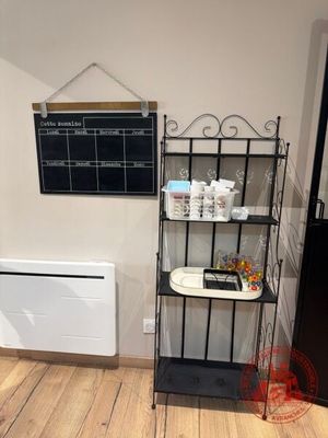 une photo d'une cuisine avec un tableau noir accroché au mur et un radiateur blanc