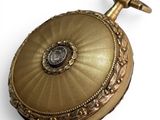 a gold pocket watch with a diamond in the center