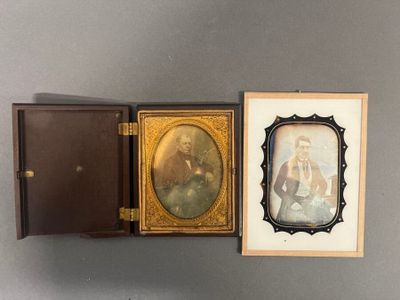 trois photos encadrées représentant un homme et une femme, rangées dans une boîte en bois