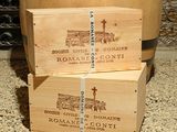 three wooden boxes stacked on top of each other in front of a barrel of wine