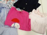 a pile of clothing on a table with a teddy bear
