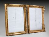 a pair of antique gold framed mirrors on a grey background