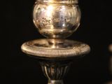 two silver candles that are sitting on a table