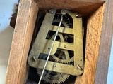 a small wooden box with a clock inside of it