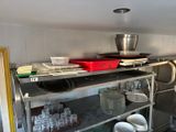 a metal shelf with dishes on it in a kitchen