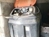 un bac noir avec un couvercle orange posé par terre à côté d'une caisse noire