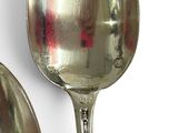 two spoons that are sitting next to each other on a table
