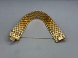 a close up of a gold bracelet on a gray surface