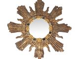 une image représentant un miroir doré en forme de soleil rayonnant sur fond blanc