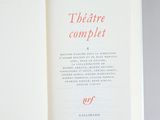 an open book with red writing on it on a gray surface