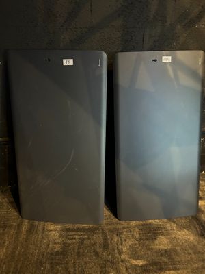 pair of two gray refrigerators sitting next to each other on a wooden floor