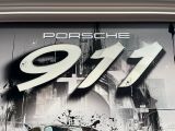 une affiche représentant une Porsche 911 sur la façade d'un immeuble