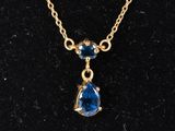 un collier en or orné d'une topaze bleue et d'une chaîne en or