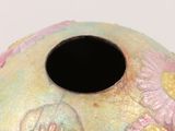a colorful vase with a black hole in the middle
