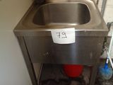 a sink in the corner of a room with a sign on it