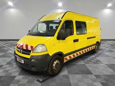 La camionnette jaune est garée sur le sol à damier du garage.
